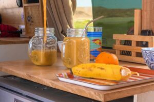 Inviting homemade smoothies poured into vintage glasses with fresh fruits on a sunny day.